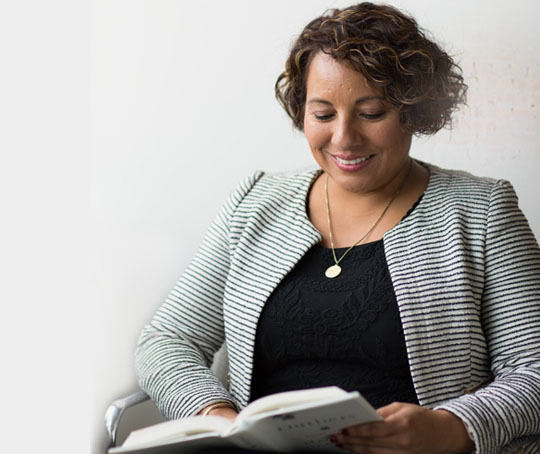 A woman sitting on a chair with a notepad